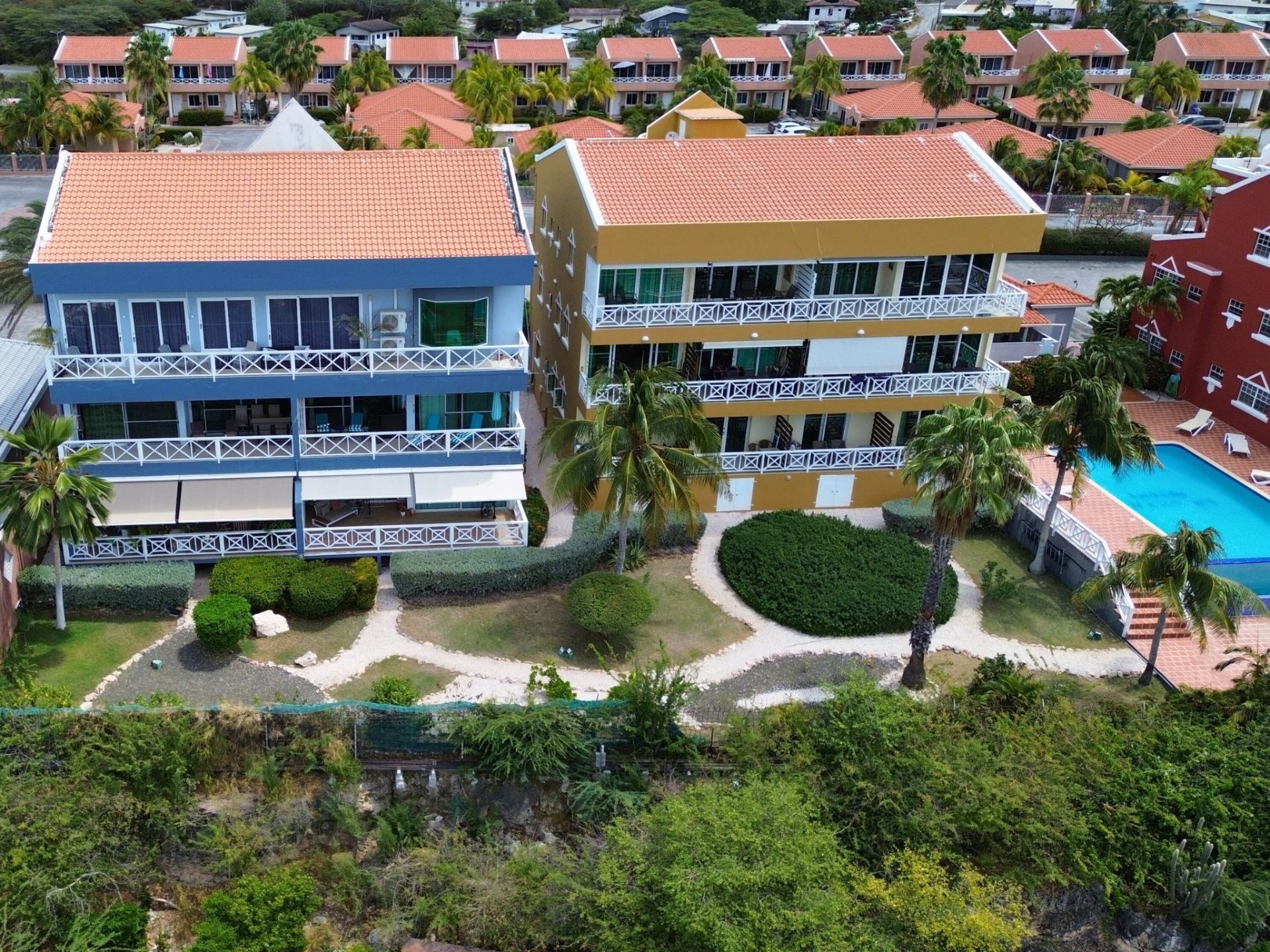 La Vista Resort Penthouse exterior view showcasing luxury rental property with spacious balconies, tropical landscaping, and swimming pool in Curaçao.