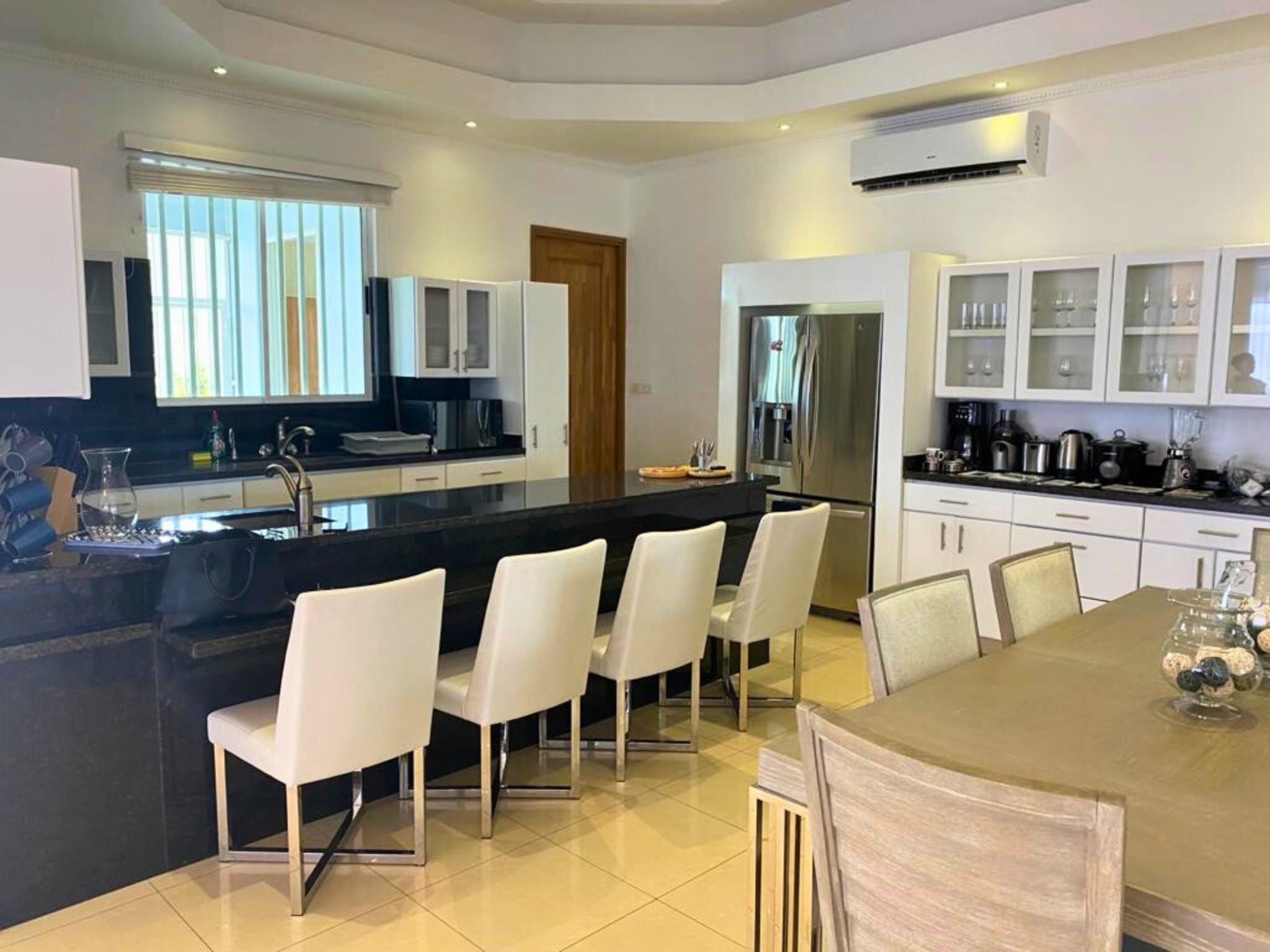 Moderne keuken in La Vista Resort Penthouse met zwart granieten aanrecht, witte kasten, en stijlvolle eetruimte.