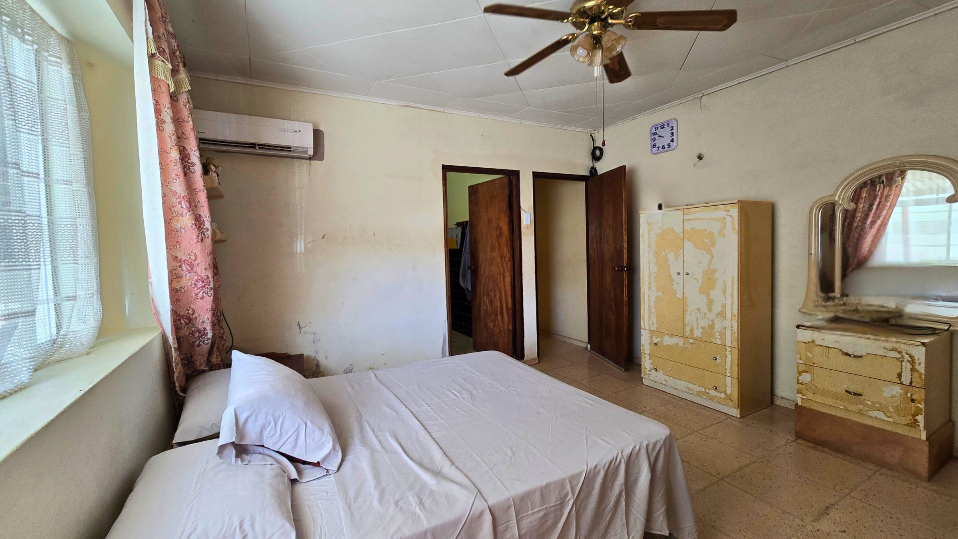 Bedroom with tiled floor, closet, and ceiling fan