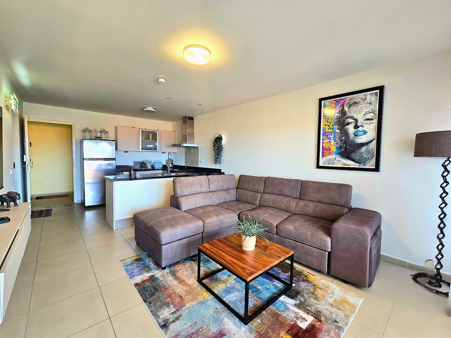 For rent Blue Bay 1-bedroom apartment - bright living room with sectional sofa and coffee table.
