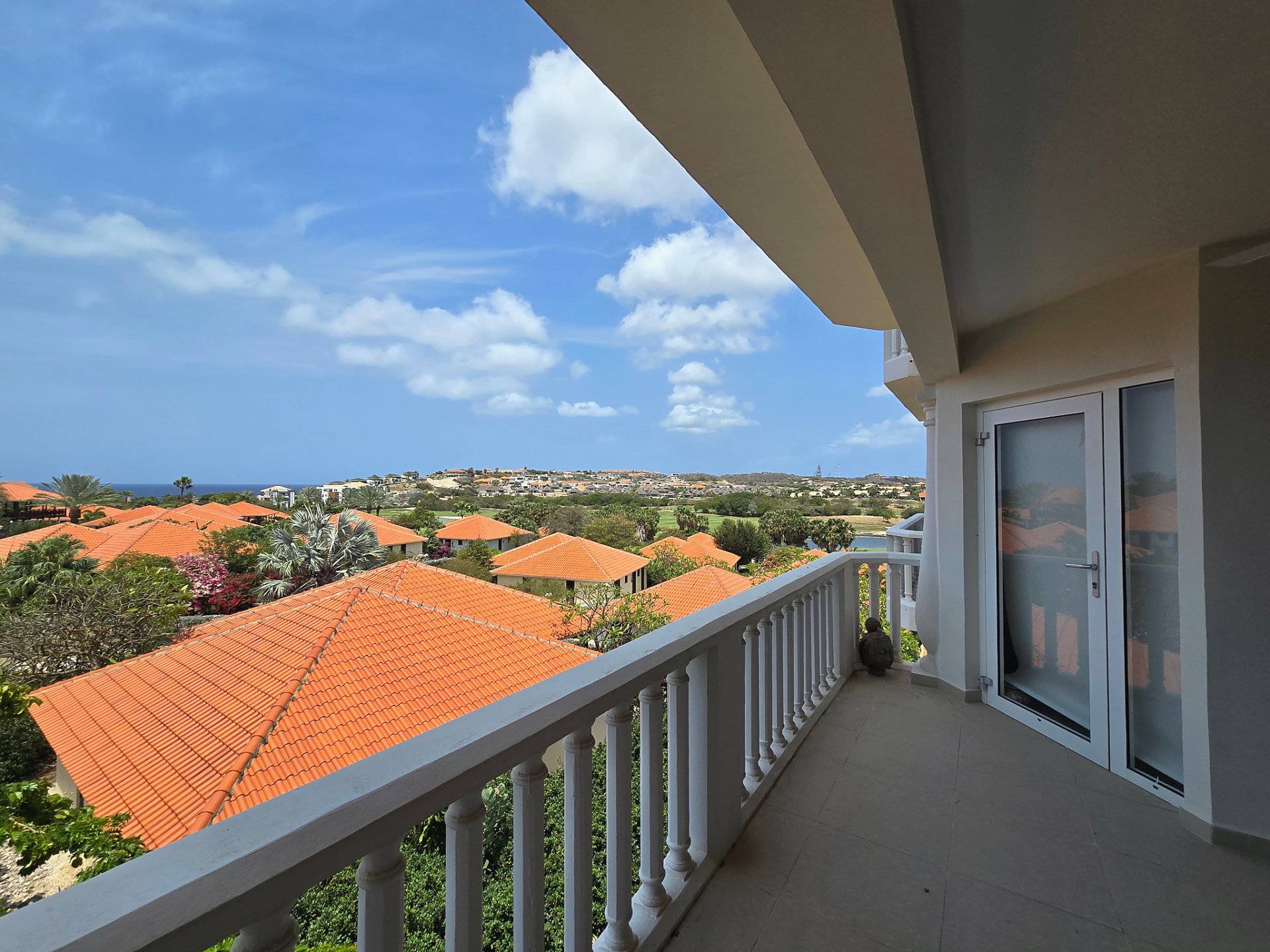 For rent Blue Bay 1-bedroom apartment - balcony view over rooftops, resort grounds, and surrounding neighborhood.