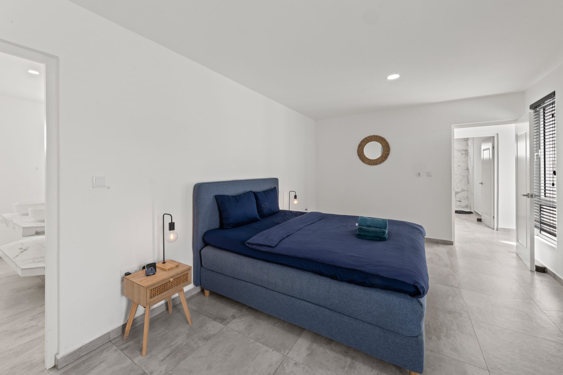 for sale in curaçao real estate in turnkey villa in Vredenberg bedroom with blue bedspread and modern styling