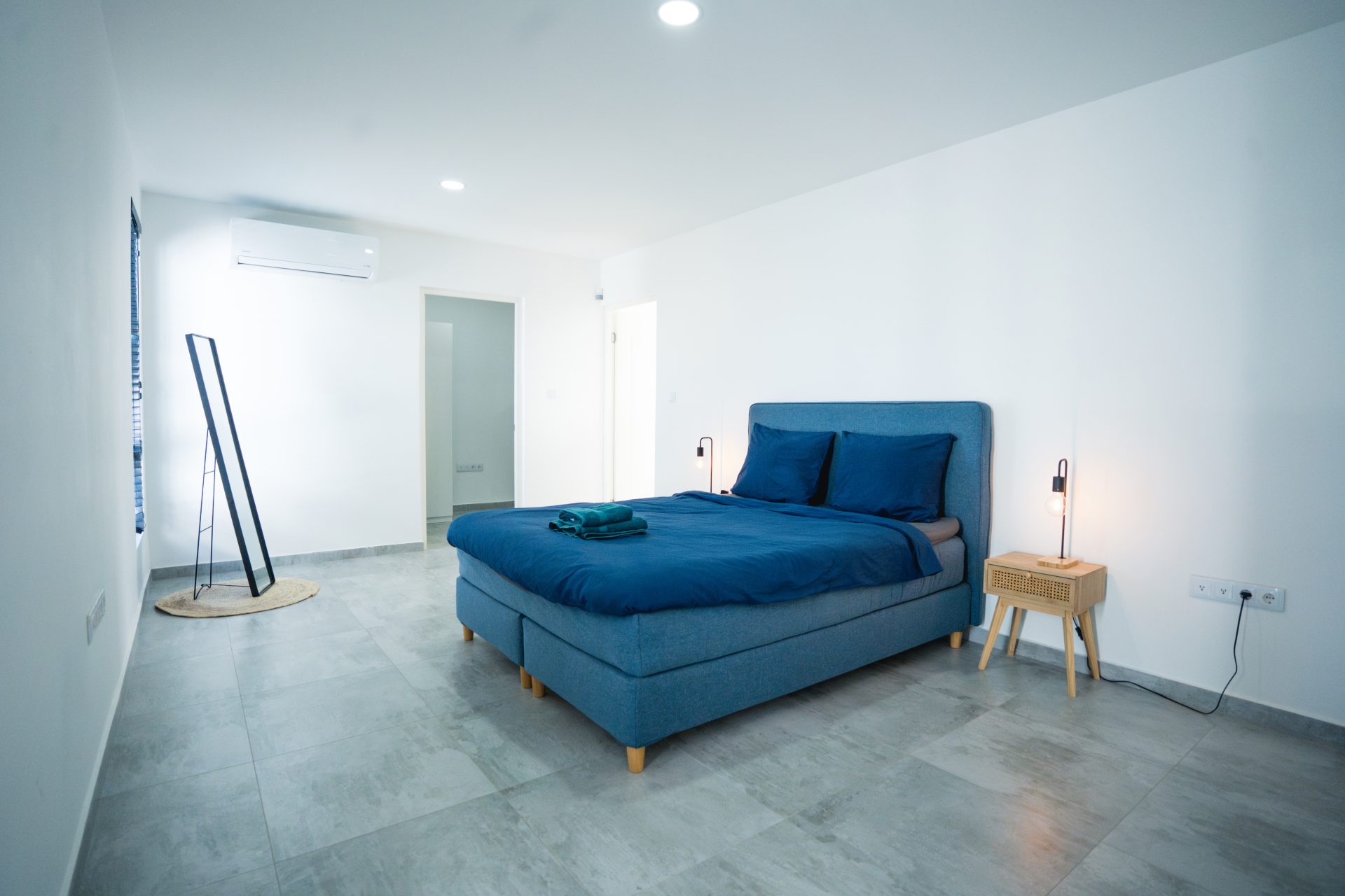 Curacao real estate for sale – Master bedroom featuring a king-size bed, minimalist decor, and natural light.