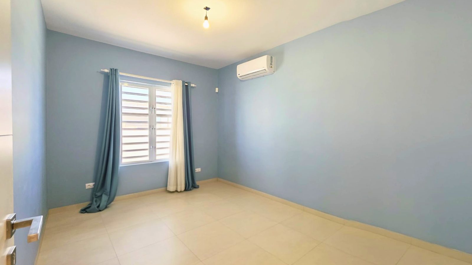 villa for sale in curaçao real estate at Harmonie spacious bedroom with soft tones and natural ventilation