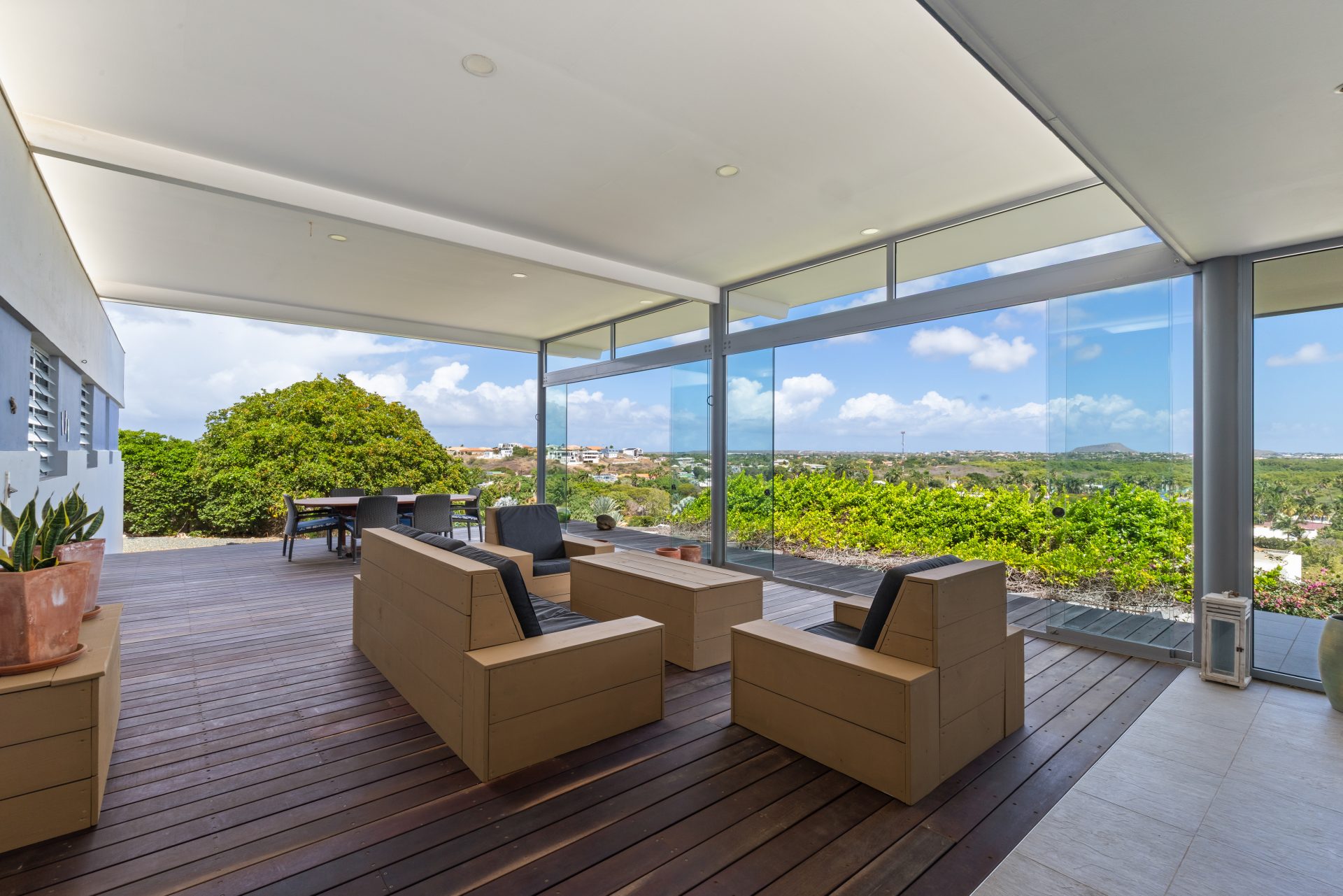 Curaçao real estate for sale spacious outdoor lounge area with sectional sofa and panoramic ocean views.