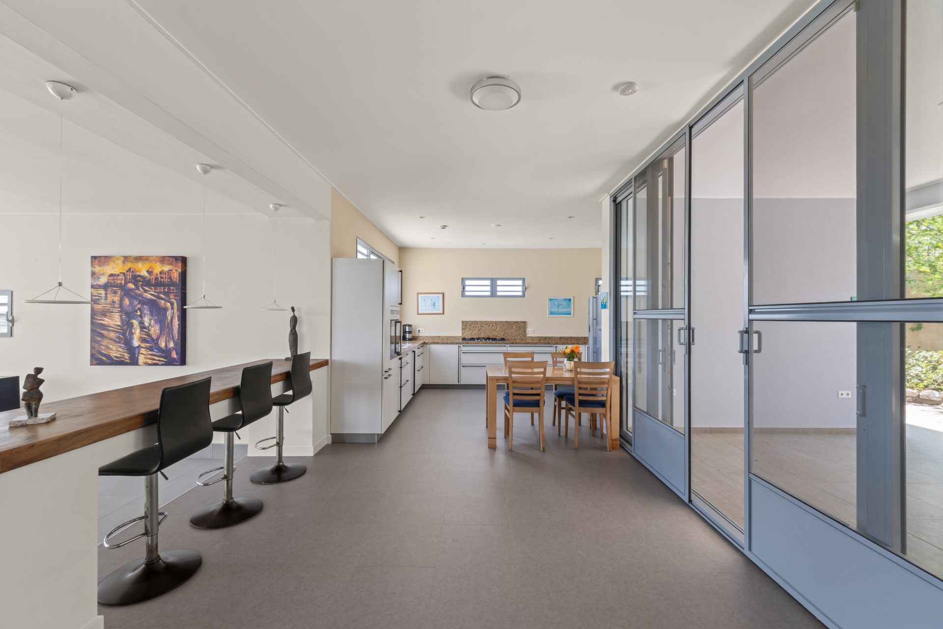 Curaçao real estate for sale bright open-plan living room with large windows and modern furnishings.