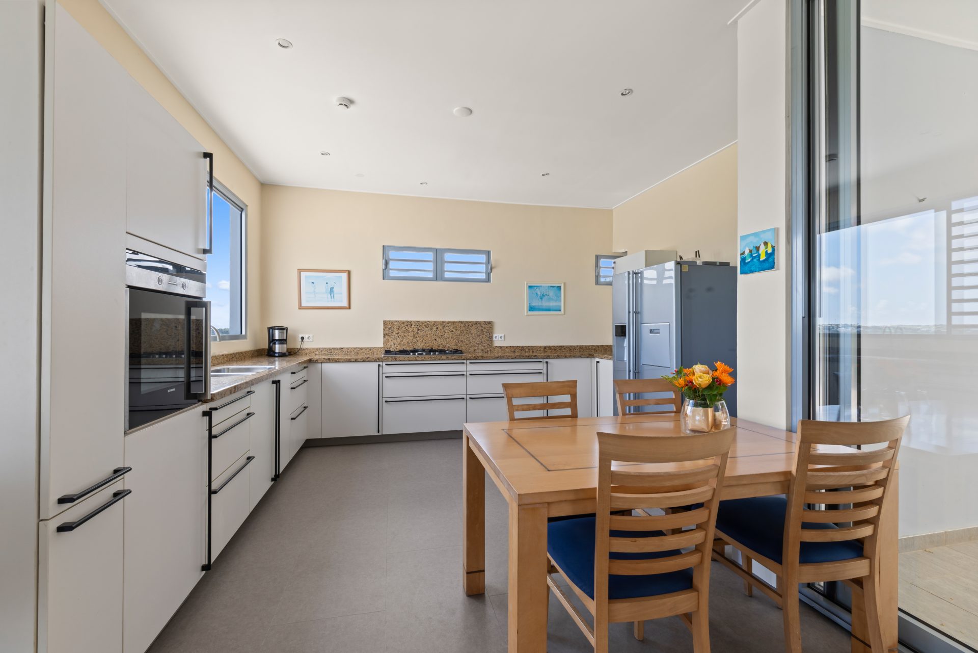 Curaçao real estate for sale modern kitchen with white cabinetry and long hallway design.