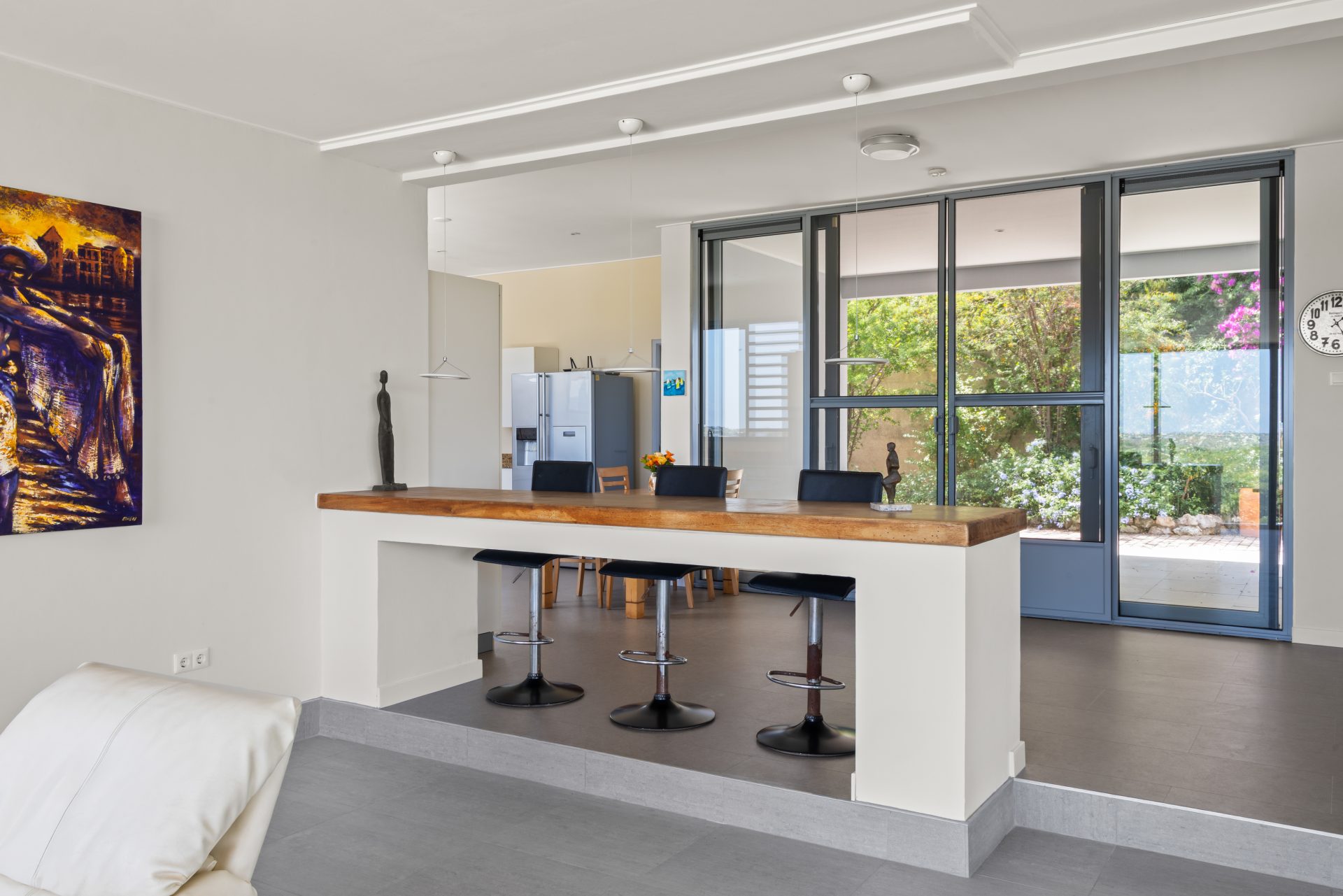 Curaçao real estate for sale minimalist interior space with bar stools and open kitchen layout.
