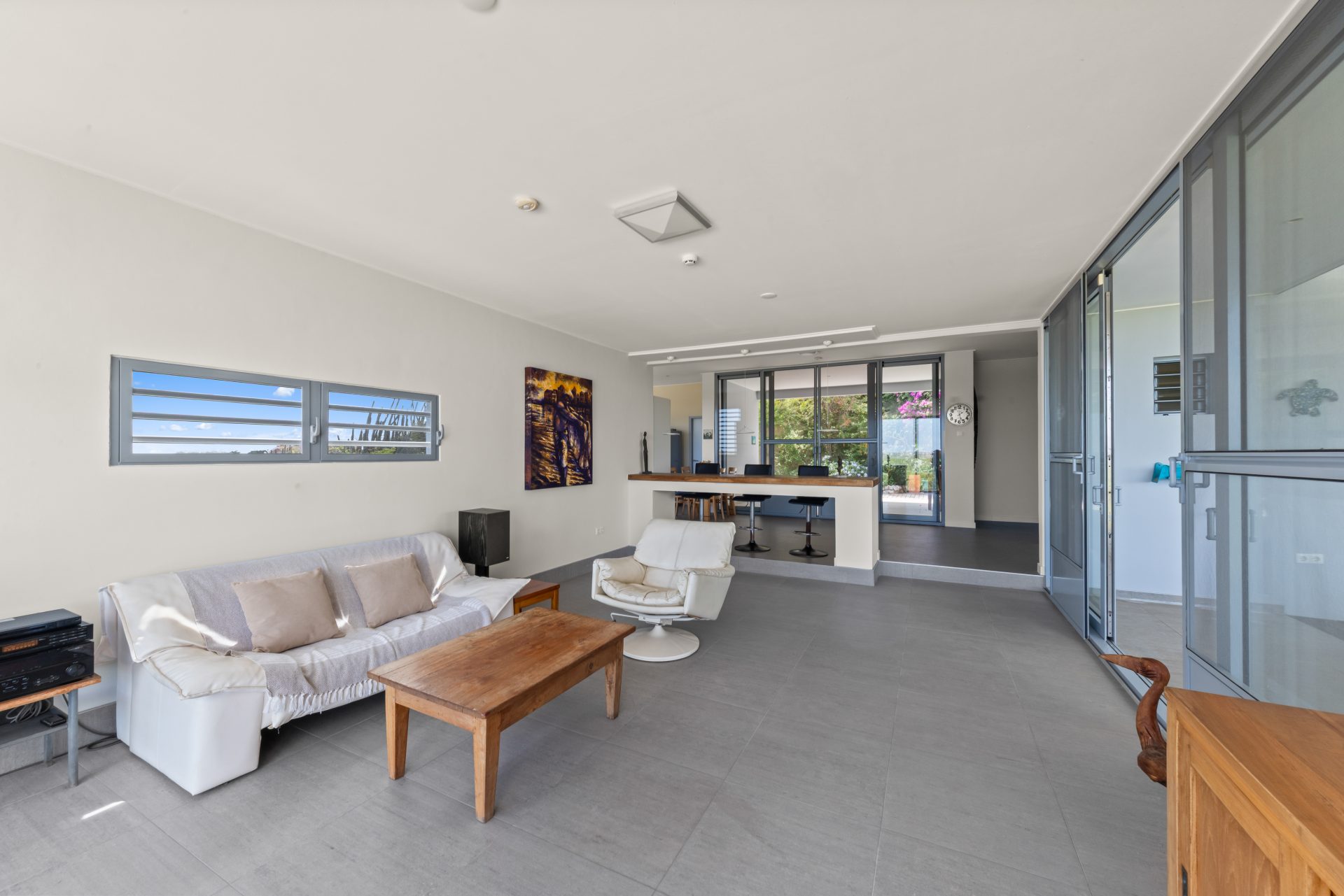 Curaçao real estate for sale bright open-plan living room with large windows and modern furnishings.