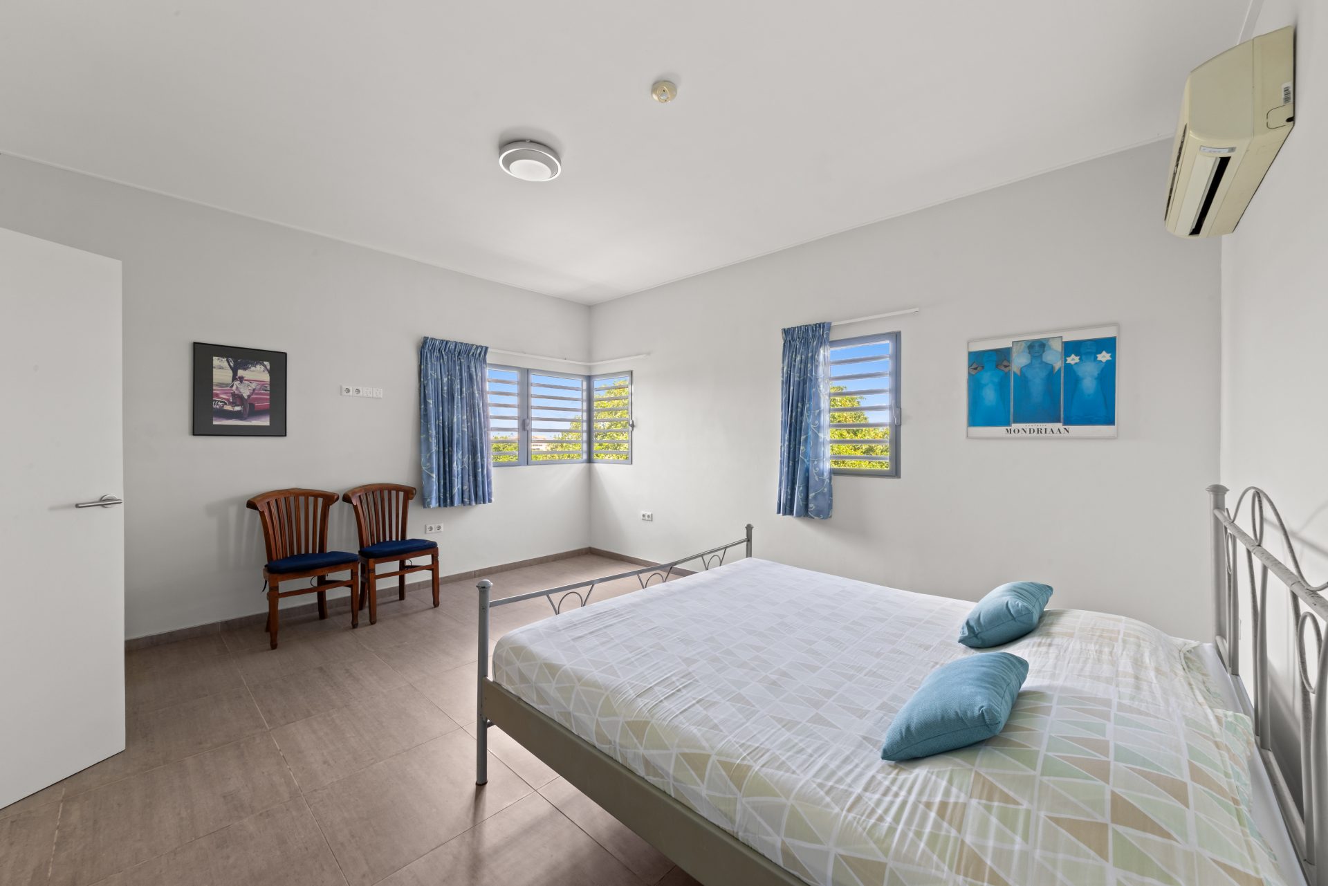 Curaçao real estate for sale spacious bedroom with windows and neutral finishes.