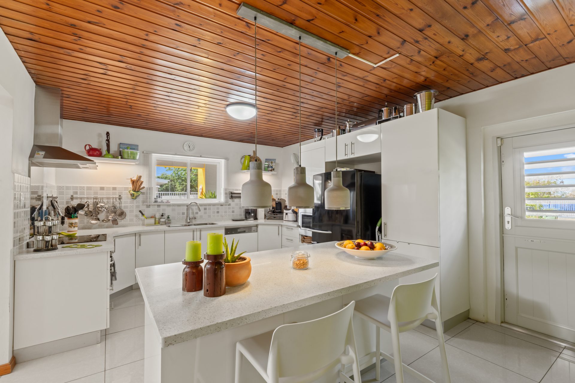 jan thiel villa for sale - modern white kitchen with island and wooden ceiling detail