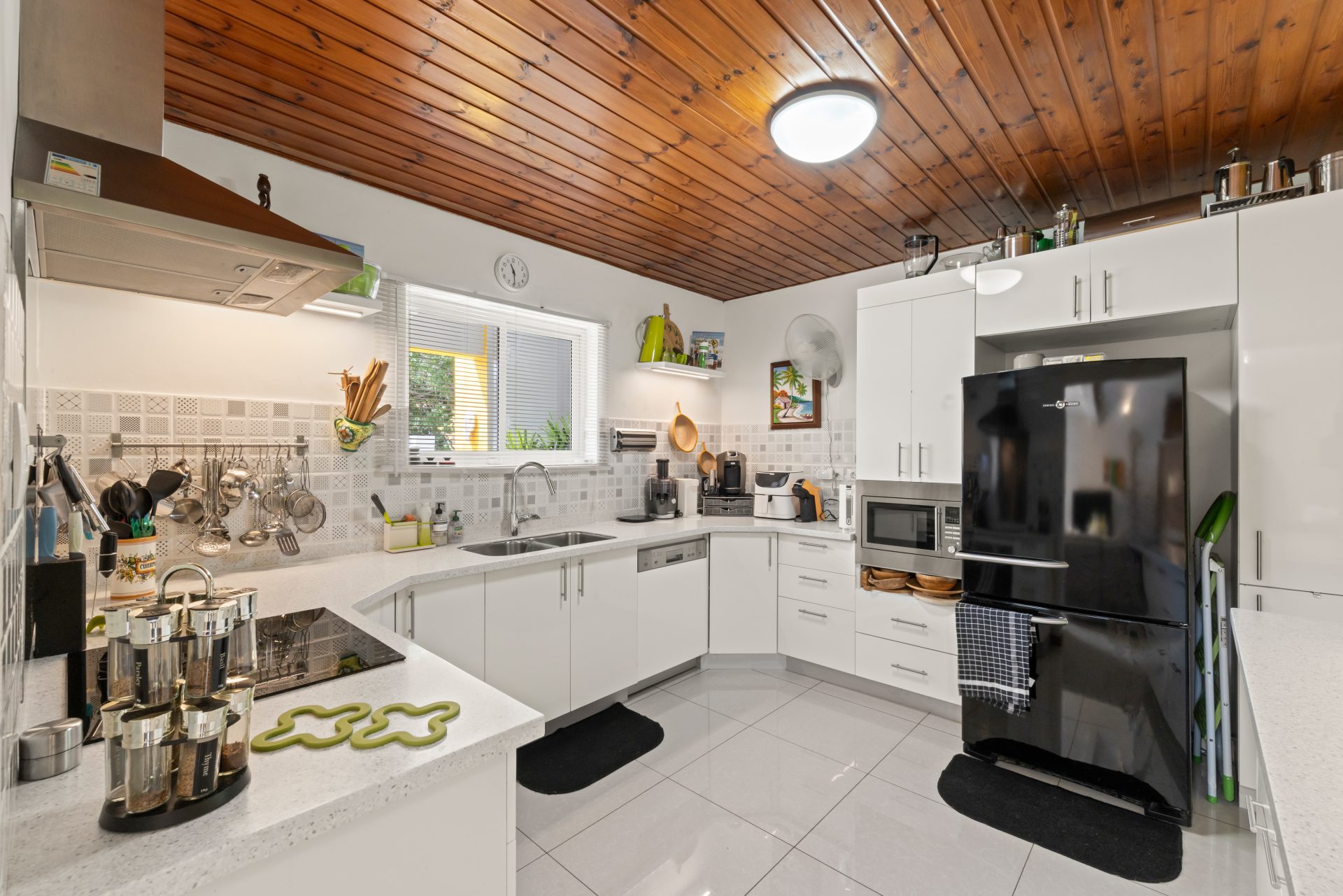 jan thiel villa for sale - modern white kitchen with island and wooden ceiling detail