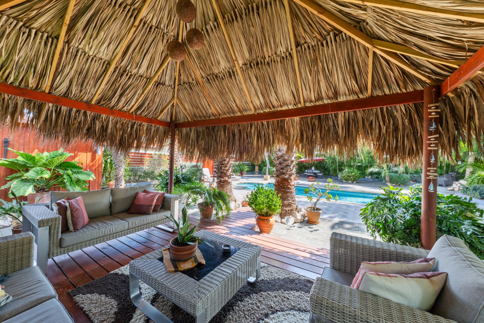 jan thiel villa for sale - shaded palapa seating area with outdoor sofa and tropical décor