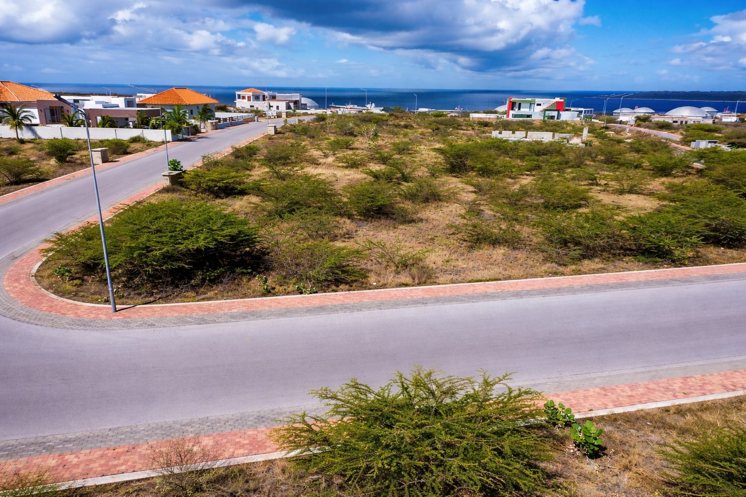 Harmonie lot Q5 for sale in curaçao real estate roadside view of vacant land with surrounding homes and paved access