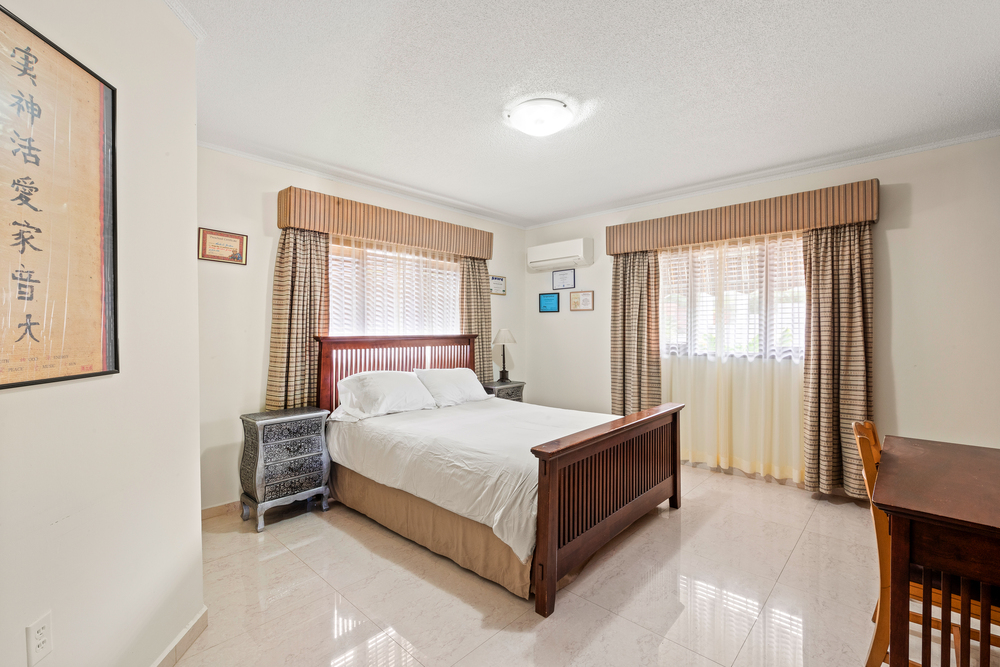 5-bedroom villa for sale in curaçao real estate in Jan Thiel bedroom with wood frame bed and warm finishes