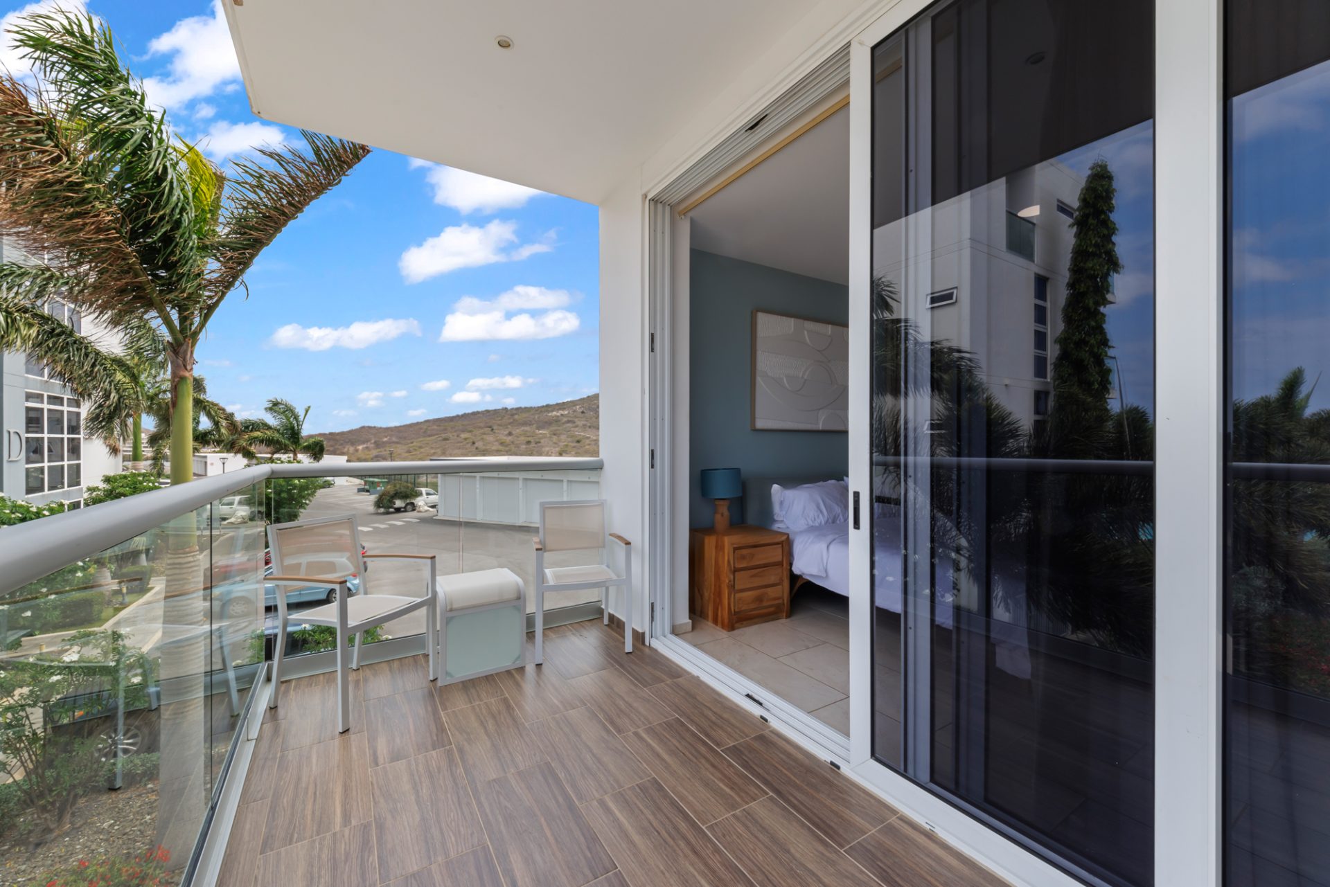 Covered balcony of a fully furnished condo for sale in resort with sliding glass doors.