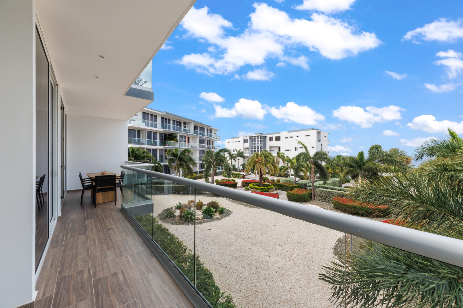 Spacious terrace at a fully furnished condo for sale in resort with open garden views.