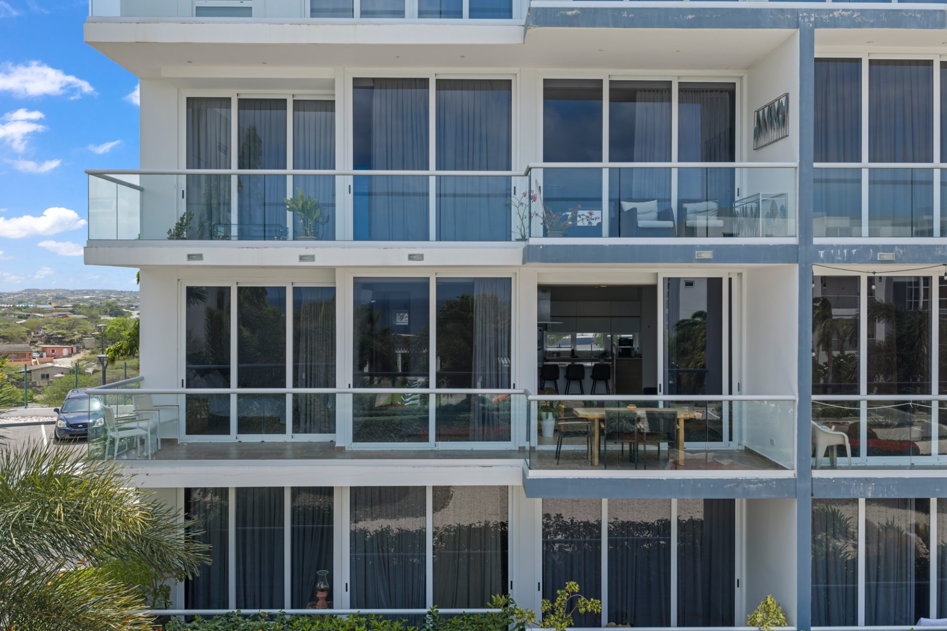 Modern resort facade of a fully furnished condo for sale in resort with glass balcony railings.